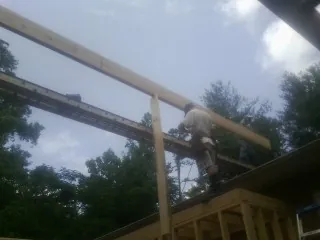 Carpenter setting a ridge beam over a new addition frame — Ice Dam Removal by Roofing Brothers in Dunlap