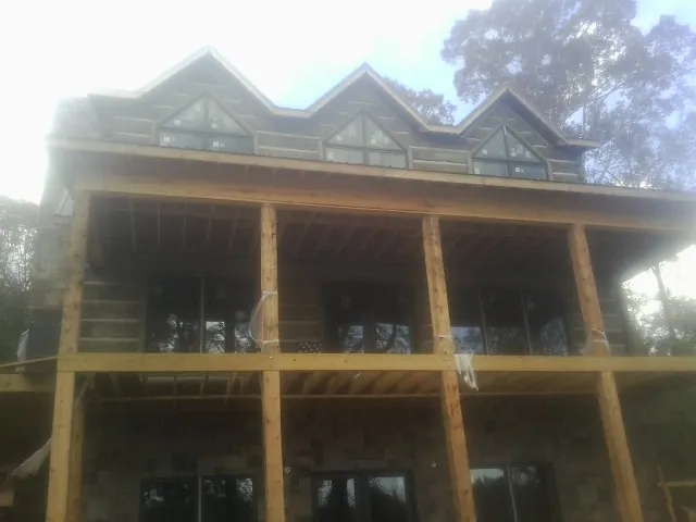 Dormers and porch framing on a large log home under construction — Roof Coating work by our crew in Dunlap